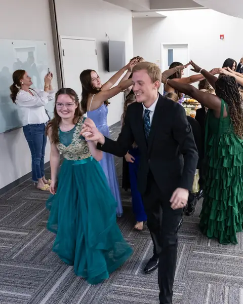 A couple dancing through an arch of raised arms