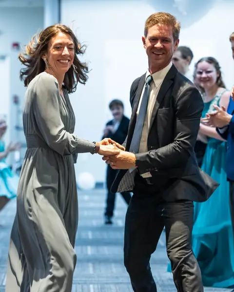 A couple dancing down the line while guests clap